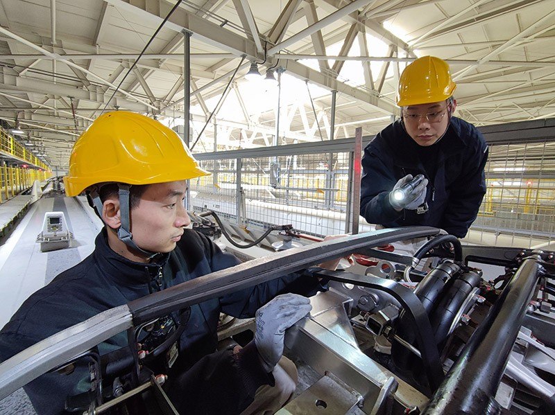 除夕當(dāng)天，動車組機械師正在測量動車組受電弓碳滑板厚度。王子俊 攝