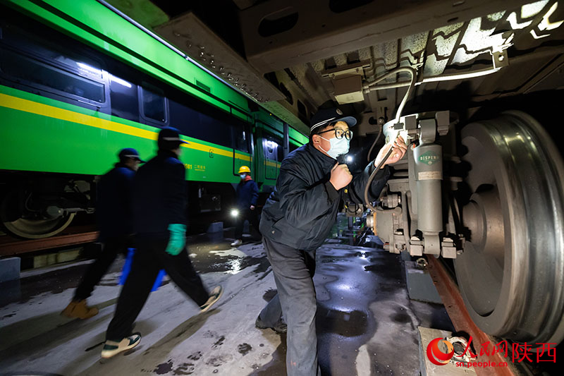 1月26日，西安客車車輛段，鐵路檢修“小哥”正在檢查動力集中型動車組走行部件。劉翔攝