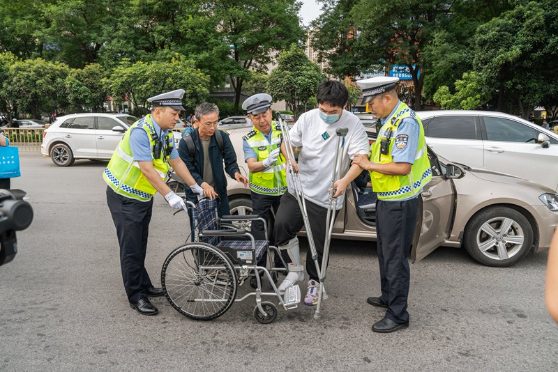 考生坐輪椅赴考，西安交警合力護(hù)送。孫崇明 攝