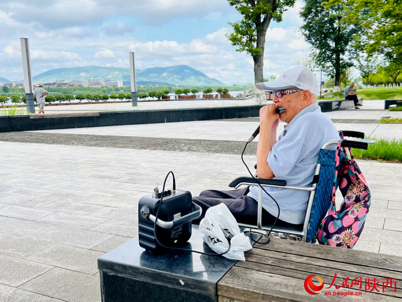 94歲的張大爺每天都會(huì)到天漢濕地公園憩息吹口琴。人民網(wǎng)記者 孫挺攝